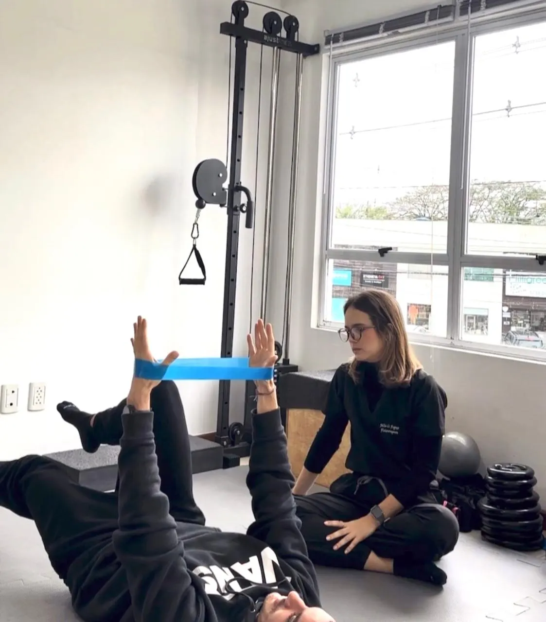 Consulta de fisioterapia com exercício assistido usando faixa elástica